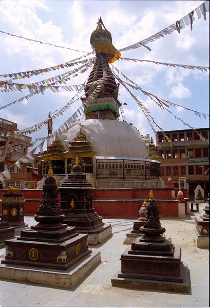 Temple bouddhiste avec drapeaux à prières, nez de Bouddha en forme du symbole de l'unité et des moulins à prières autour du temple