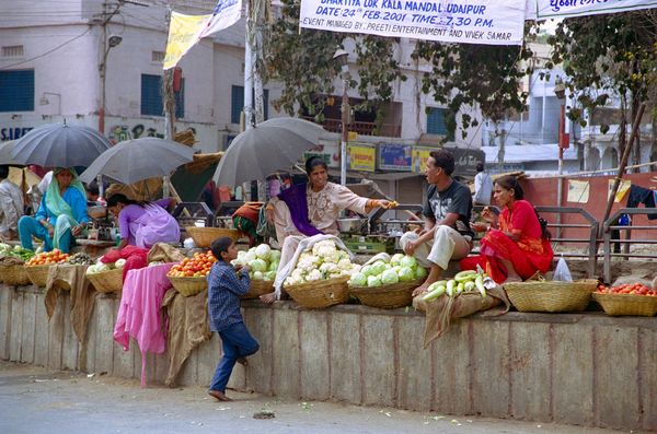 Marché improvisé sur les marches du rond-point. Il fait chaud, sortons les parapluies!