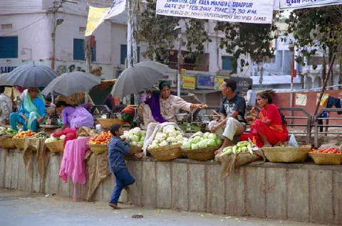 Marché improvisé sur les marches du rond-point. Il fait chaud, sortons les parapluies!