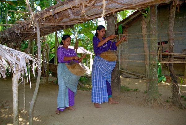 Fabrication de corde... la dame tourne la roue pendant que deux autres femmes filent la fibre de noix de coco